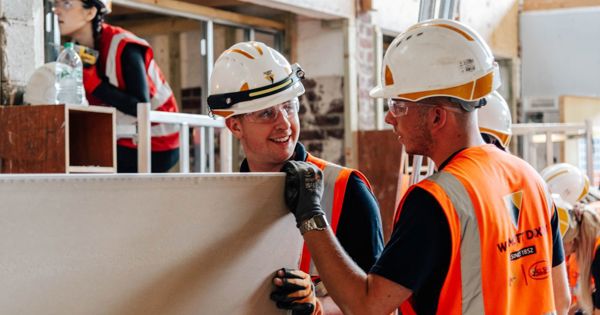 A construction apprentice working on site under supervision